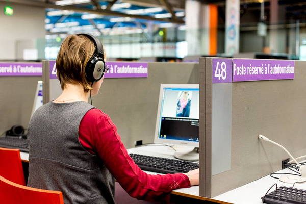 Jeune fille travaillant sur un ordinateur dans une des cabines de l'espace autoformation