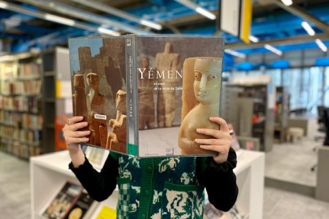 usager tenant un livre dans l'espace Histoire de la bibliothèque