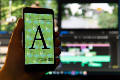 personne consultant le programme de la bibliothèque sur un téléphone