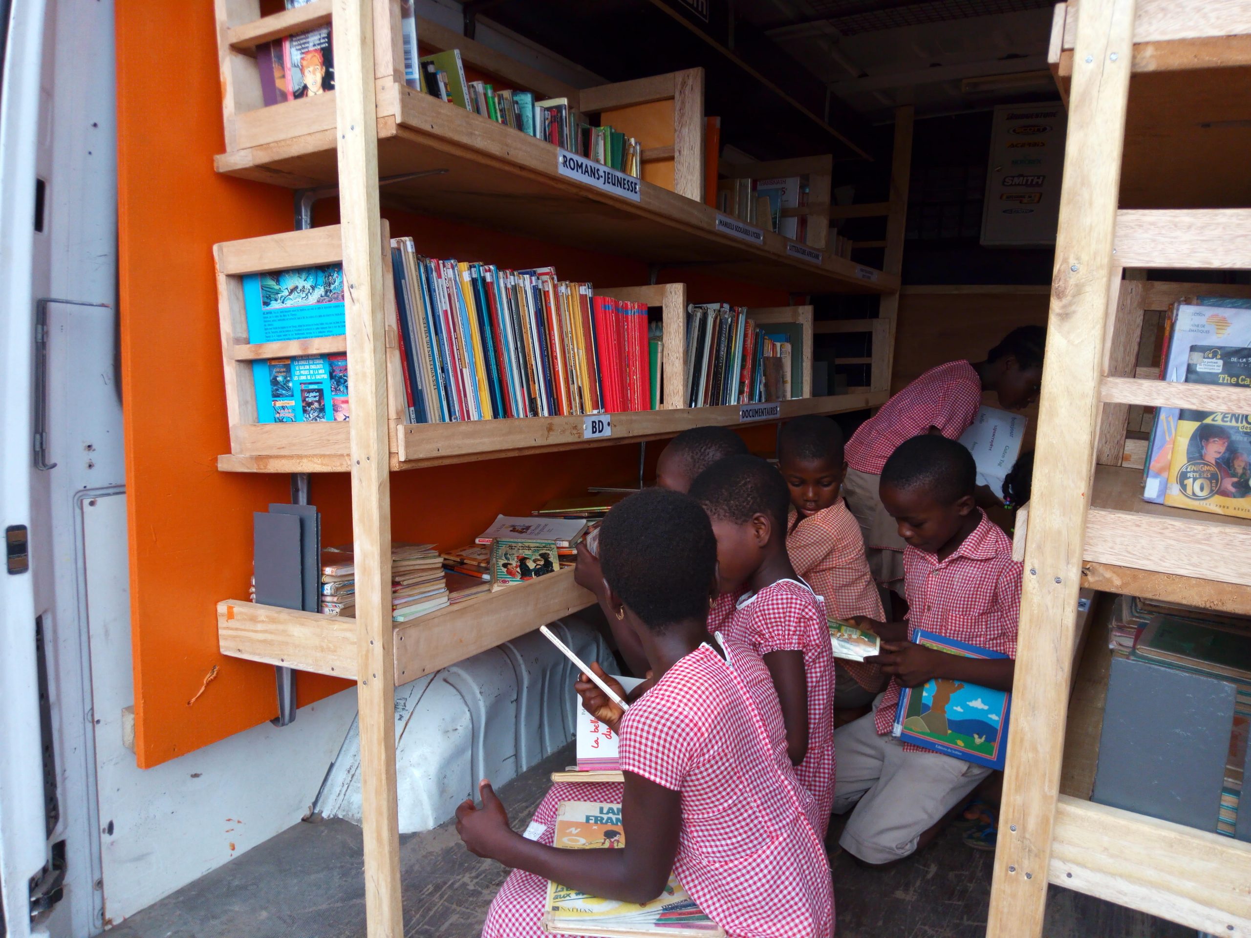 Enfants à l'intérieur du bibliobus en train de lire