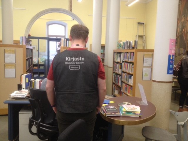 bibliothécaire de dos avec gilet signalant sa fonction