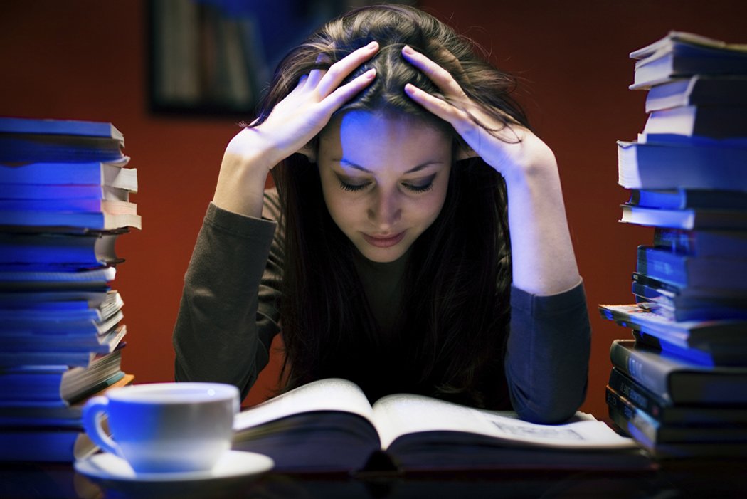 photo d'une jeune femme en train de lire qui se tient la tête