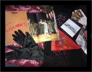 Photographie en couleurs montrant le travail des élèves sur Carmen : livret, gants noirs, éventail