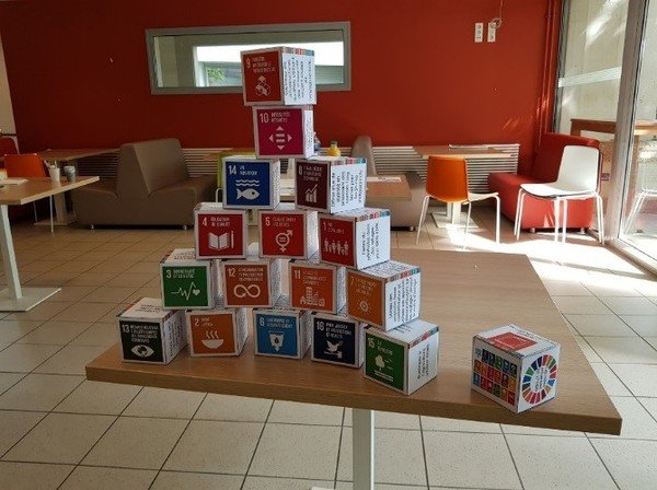 Photographie de cubes en carton entassés avec des inscriptions d'objectifs de développement durable