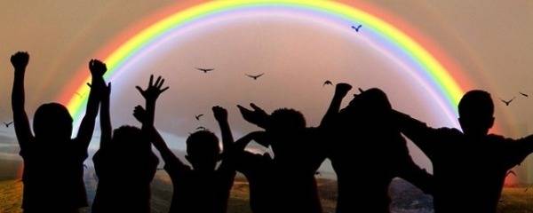 Photo d'enfants devant un arc-en-ciel