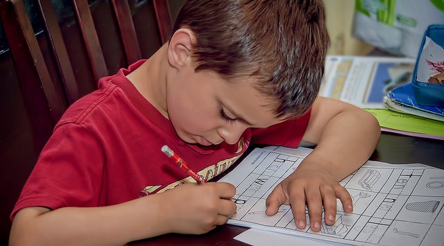 photographie d'un enfant faisant ses devoirs