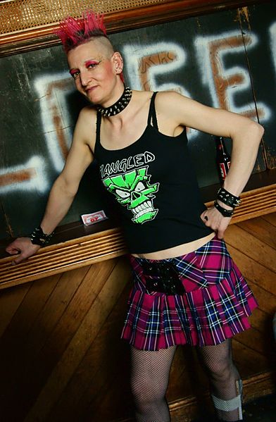 Photographie d'une jeune femme punk portant une jupe tartan