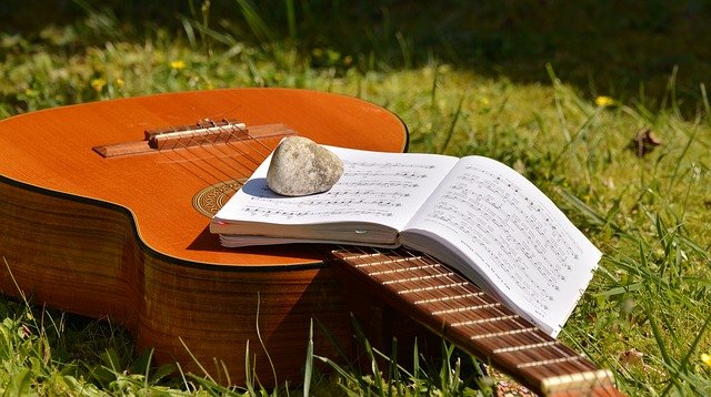 Photographie d'une guitare avec un livre