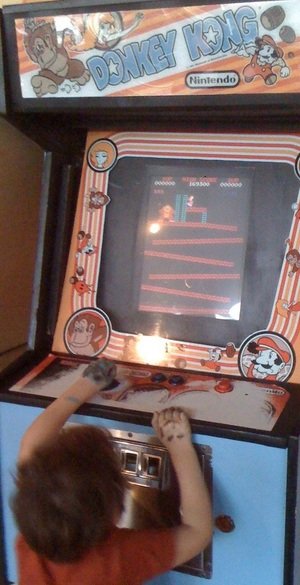 enfant jouant à Donkey Kong sur borne d'arcade