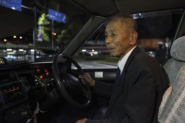 Un vieil homme japonais travaille comme taxi