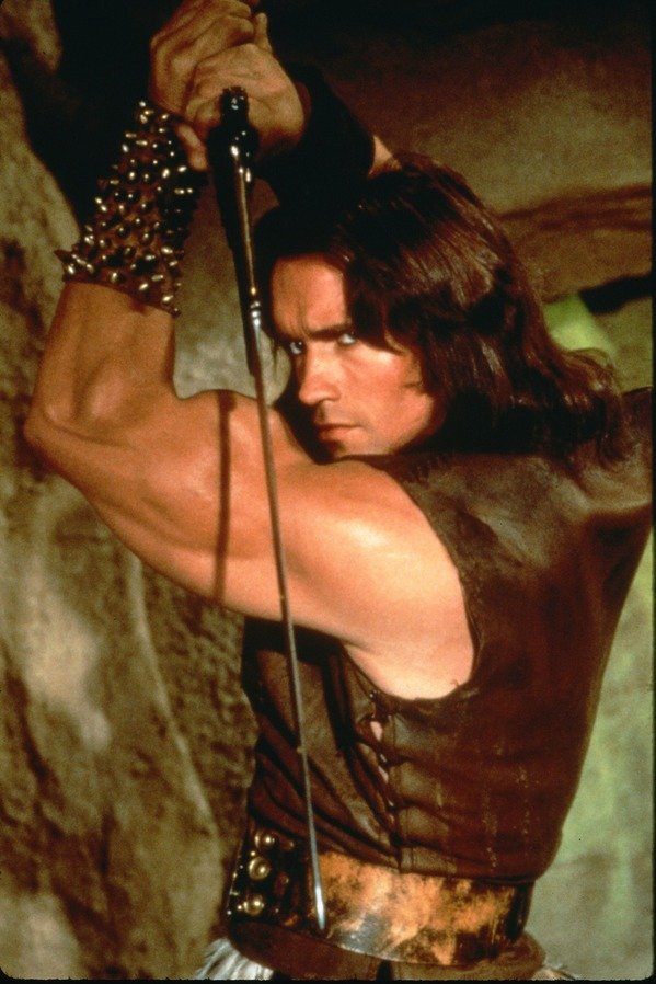 Arnold Schwarzenegger, l'épée à la main, en tenue de barbare