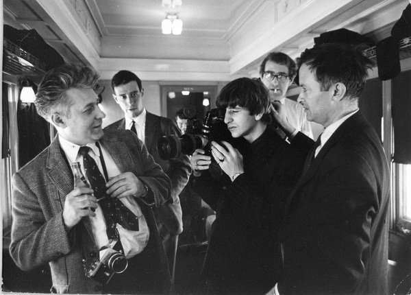 Les Beatles filment les Maysles dans un train, noir et blanc.