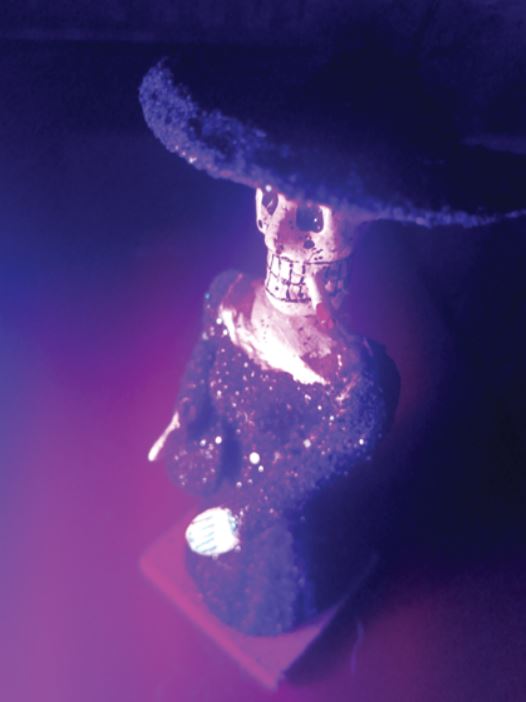 Une statuette Mexicaine représentant une tête de mort avec une cigarette